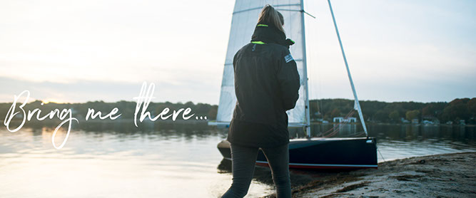 Wandersegeln mit der KARU-Jolle. Jollensegeln mit Zeltplane. Eine KARU-Jolle liegt am Strand.